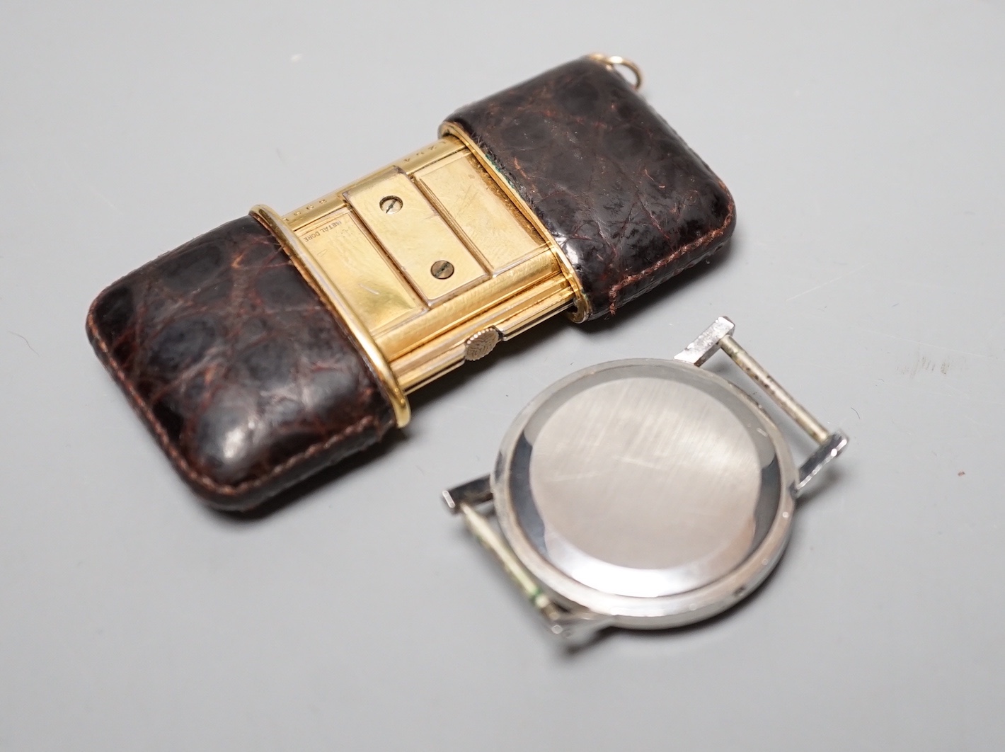 A Movado leather mounted gilt metal travelling timepiece, 49mm and a stainless steel Movado manual wind wrist watch(lacking winding crown).